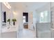 Elegant bathroom featuring a double vanity, walk-in shower, and view through the doorway to the Primary suite at 15 Harvest View Way, Franklinton, NC 27525