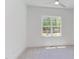 This bedroom has neutral carpeting, white walls, a large window, a ceiling fan, and white trim for a bright look at 15 Harvest View Way, Franklinton, NC 27525