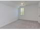 This bedroom features neutral carpeting, white walls, a large window, a ceiling fan, and white trim for a bright look at 15 Harvest View Way, Franklinton, NC 27525