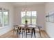 Bright dining room featuring hardwood floors, a modern light fixture, and a large window with scenic outdoor views at 15 Harvest View Way, Franklinton, NC 27525