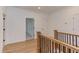 Hallway with wood floors, doors, and a staircase with black railings at 15 Harvest View Way, Franklinton, NC 27525