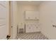 Bright laundry room featuring white cabinetry, a sink, countertop, and a decorative tile floor at 15 Harvest View Way, Franklinton, NC 27525