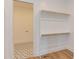 Large walk-in closet with custom shelving, storage, and access to a laundry room with patterned tile flooring at 15 Harvest View Way, Franklinton, NC 27525