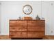 Bedroom view of a wooden dresser with decorative items and a round mirror at 1603 Sutton Dr, Raleigh, NC 27605