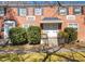 Brick two-story townhouse with black shutters and manicured landscaping with inviting covered entrance at 1603 Sutton Dr, Raleigh, NC 27605