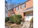 Beautiful brick townhome featuring black shutters, trimmed hedges, and a welcoming entrance at 1603 Sutton Dr, Raleigh, NC 27605