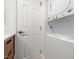 Bright laundry room features a stacked washer and dryer for convenient in-home laundry at 1603 Sutton Dr, Raleigh, NC 27605