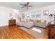 Bright living room with hardwood floors, a large sectional couch, and updated ceiling fan at 1603 Sutton Dr, Raleigh, NC 27605