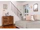 Cozy living room with staircase, featuring hardwood floors, a sectional couch, and natural light at 1603 Sutton Dr, Raleigh, NC 27605