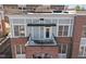 Exterior view of red brick building with covered balcony and black iron railing at 201 Finsbury St # 302, Durham, NC 27703