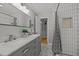 Bright bathroom featuring double vanity, modern fixtures, and tiled shower at 208 Hardwood Ridge Ct, Clayton, NC 27520