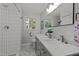 Bright bathroom featuring double vanity, modern fixtures, and tiled shower at 208 Hardwood Ridge Ct, Clayton, NC 27520