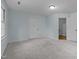 Light blue bedroom featuring plush carpet, a window, and a door at 208 Hardwood Ridge Ct, Clayton, NC 27520