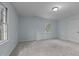 Light blue bedroom featuring plush carpet, a window, and a door at 208 Hardwood Ridge Ct, Clayton, NC 27520
