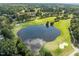 Picturesque aerial view of a golf course with a pond and lush green fairways at 208 Hardwood Ridge Ct, Clayton, NC 27520