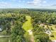 Wide aerial shot of a golf course and some houses hidden among tall, lush trees at 208 Hardwood Ridge Ct, Clayton, NC 27520