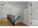 Upstairs hallway featuring hardwood floors, a black railing, and a view of a bedroom at 208 Hardwood Ridge Ct, Clayton, NC 27520