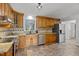 Spacious kitchen with stainless steel appliances, wood cabinetry, tile backsplash, and natural light at 208 Hardwood Ridge Ct, Clayton, NC 27520
