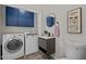 Functional laundry room with laundry sink, gray cabinets, and tile flooring at 208 Hardwood Ridge Ct, Clayton, NC 27520