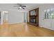 Cozy living room showcasing hardwood floors, brick fireplace, ceiling fan, and natural light at 208 Hardwood Ridge Ct, Clayton, NC 27520