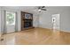 Bright living room featuring hardwood floors, brick fireplace, ceiling fan, and natural light at 208 Hardwood Ridge Ct, Clayton, NC 27520