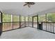Inviting screened porch with white wood deck, black railings, and view of the surrounding trees at 208 Hardwood Ridge Ct, Clayton, NC 27520
