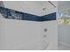 Tiled shower showcasing white subway tile, blue accent stripe, shower head, and fixtures at 208 Hardwood Ridge Ct, Clayton, NC 27520