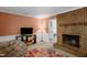 Comfortable living room featuring a brick fireplace, television, and modern chair at 214 Woodcrest Ave, Smithfield, NC 27577