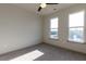 Carpeted bedroom featuring two large windows and neutral color scheme, providing ample natural light at 2300 Gathering Sq Ct, Fuquay Varina, NC 27526