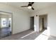 Sunlit bedroom with neutral carpet, ceiling fan, and multiple doorways leading to other rooms at 2300 Gathering Sq Ct, Fuquay Varina, NC 27526