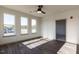 Bright bedroom featuring three large windows and modern ceiling fan, providing ample natural light and air circulation at 2300 Gathering Sq Ct, Fuquay Varina, NC 27526