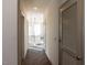 Bright hallway featuring wood floors leads to a modern kitchen with stainless steel appliances at 2300 Gathering Sq Ct, Fuquay Varina, NC 27526