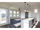 Modern kitchen features a large island, granite counters, stainless appliances, and bright sunny windows at 2300 Gathering Sq Ct, Fuquay Varina, NC 27526