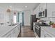 A kitchen with stainless steel appliances, white cabinets, and wood flooring at 2440 Tonoloway Dr, Raleigh, NC 27610