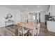 Bright dining area leading to a kitchen with island and stainless steel appliances at 2440 Tonoloway Dr, Raleigh, NC 27610