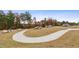 A paved path winds through landscaped lawns and trees, accented by decorative boulders in the community at 2440 Tonoloway Dr, Raleigh, NC 27610