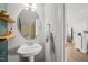 Stylish pedestal sink in bathroom with decorative mirror and natural wood accent shelf at 2715 Edmund St, Durham, NC 27705