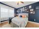 Inviting bedroom with navy blue walls, a gallery of art, and hardwood floors at 2715 Edmund St, Durham, NC 27705