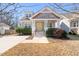 Charming home featuring a welcoming front porch, shingle detailing, a bright yellow front door, and manicured landscaping at 2715 Edmund St, Durham, NC 27705