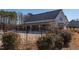 Clubhouse featuring a metal roof, surrounded by manicured landscaping and an enclosed outdoor area at 2929 Great Lawn Rd, Apex, NC 27502