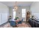 Dining room with a chandelier, round table, blue chairs, and a colorful rug at 2929 Great Lawn Rd, Apex, NC 27502