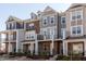 Charming multi-story townhomes with appealing exteriors, showcasing architectural details and curb appeal in a pleasant setting at 2929 Great Lawn Rd, Apex, NC 27502