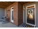 Inviting front porch with a brick pillar, perfect for relaxing with rocking chairs, and a welcoming front door at 2929 Great Lawn Rd, Apex, NC 27502