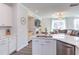 Open kitchen with stainless dishwasher, island with sink, and white cabinets at 2929 Great Lawn Rd, Apex, NC 27502
