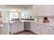 Open kitchen with stainless dishwasher, island with sink, and white cabinets at 2929 Great Lawn Rd, Apex, NC 27502
