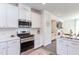 Bright kitchen with stainless range and microwave, tile backsplash and white cabinets at 2929 Great Lawn Rd, Apex, NC 27502