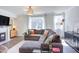 Comfortable living room featuring a cozy gray sectional, fireplace, and large windows at 2929 Great Lawn Rd, Apex, NC 27502
