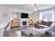 Open-concept living room with a fireplace, large sectional sofa, and plenty of natural light at 2929 Great Lawn Rd, Apex, NC 27502