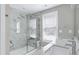 Bright bathroom featuring a double sink vanity and a glass-enclosed shower with marble-style tiling at 3010 Garner Rd # 102, Raleigh, NC 27610
