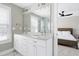 Bathroom view showcasing double vanity with white cabinets and quartz countertop, as well as mirror and bedroom at 3010 Garner Rd # 102, Raleigh, NC 27610